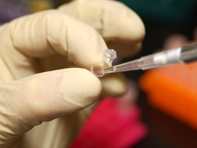 Investigadora tomando ADN de un tubo con una pipeta